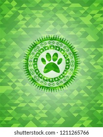 paw icon inside green emblem with mosaic ecological style background