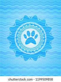 paw icon inside sky blue water wave badge.