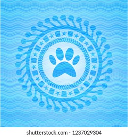 paw icon inside sky blue water wave emblem.