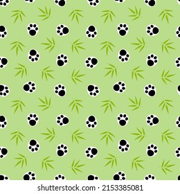 Paw prints animal panda on a green background with green bamboo leaves. Bamboo twigs and panda paws on a green background seamless pattern.	
