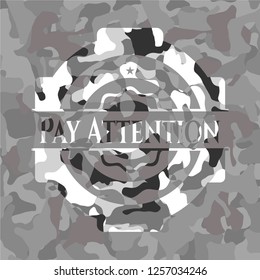 Pay Attention written on a grey camouflage texture