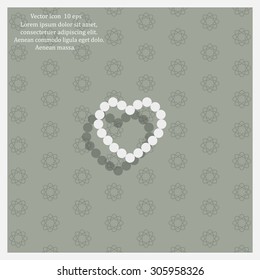 Pearl beads as heart on a white background