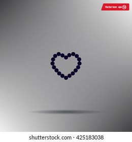 Pearl beads as heart on a white background