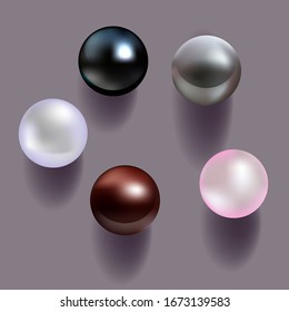 
Pearls of different colors on a gray background with shadows.