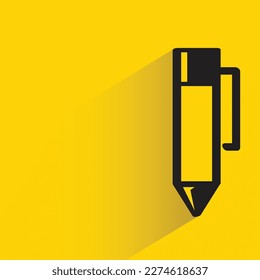 pen with shadow on yellow background