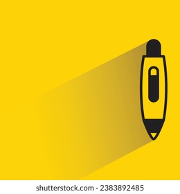 pen with shadow on yellow background
