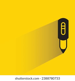 pen with shadow on yellow background