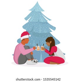 people celebrate Christmas. a young couple at a Christmas tree. the guy with the girl cocktails