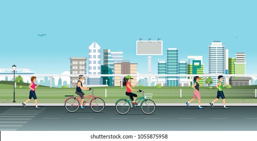 People jogging and running bicycles with backdrop buildings.