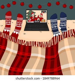 People are on the bed with knitted red and blue socks. They are watching to laptop, it is video call with friend and family in Christmas time
