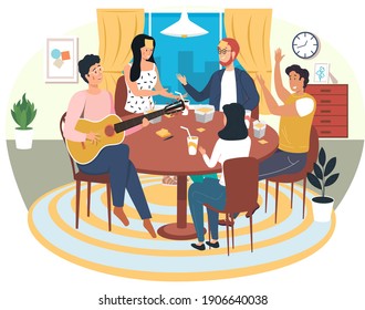 People playing board game. Man sings songs. Guy playing guitar. Friends have fun at home. Girls discuss card game on table. Entertainment and pastime in apartment. Musician uses strings on instrument