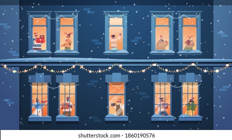 people in santa hats holding gifts mix race neighbors standing in window frames new year christmas holidays celebration self isolation concept building house facade horizontal vector illustration