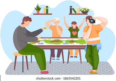 People sitting at a table and playing a board game. Guy is standing and adjusting the lens. Children joyfully raise their hands up. Family pastime at home. Man is sitting with green chips in his hands