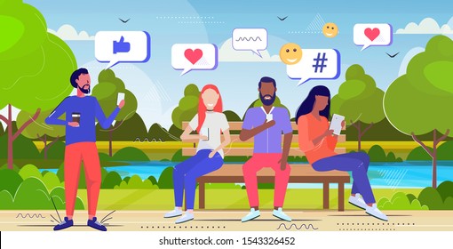 people using online mobile app social media network chat bubble communication concept mix race men women sitting at wooden bench summer park landscape background sketch full length horizontal vector
