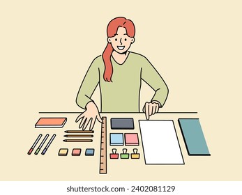 Perfectionist woman with OCD syndrome puts things in order on desktop and gets pleasure from perfectly placed stationery items. Girl with OCD disease smiles when she sees order in workplace