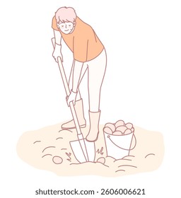 A person is actively digging soil using a shovel and a bucket in a garden or field