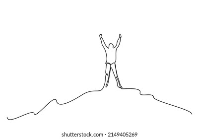 a person climbing to the top of a mountain top raises his arms in the air