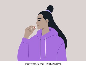 A person in a cozy purple hoodie thoughtfully prepares to take a pill, embracing a moment of self-care and reflection on health and well-being