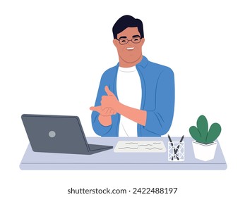 Person with Down syndrome sits at a desk uses a laptop. A man with Down syndrome works with a laptop in the office. Social integration concept.