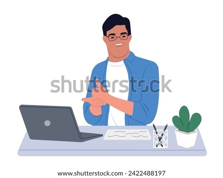 Person with Down syndrome sits at a desk uses a laptop. A man with Down syndrome works with a laptop in the office. Social integration concept.