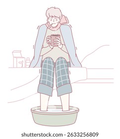A person enjoys a long, warm foot soak while sipping on a hot drink, completely wrapped in comfort and coziness