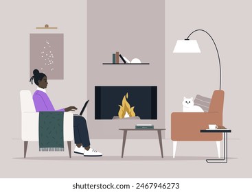 A person enjoys working on their laptop while sitting in a chair by the warm fireplace, with a cat resting nearby on another chair, and a book on the coffee table