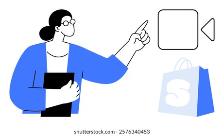 A person with glasses is holding a black object and pointing at a play button symbol. Beside them is a blue shopping bag with a white S. Ideal for online shopping, e-commerce, tutorials, digital