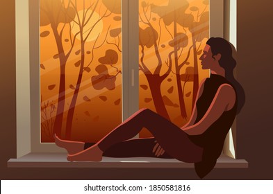 Person looking out window. Girl looks out window during autumn, orange light from the sun silhouettes trees. 