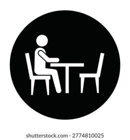 A person sits alone at a table with one chair across from them in a simple setting.