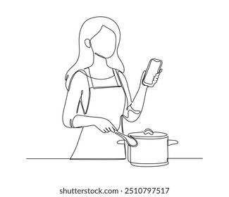 A person standing, stirring a pot with one hand and holding a smartphone in the other. The individual appears to be multitasking, combining cooking with using a digital device