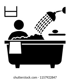 
A person is taking bath in a bathtub with shower

