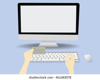 A person using computer for online shopping holding credit card.