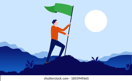 Personal triumph - Man celebrating life goals and victory by raising green flag on hilltop with landscape and sun in background