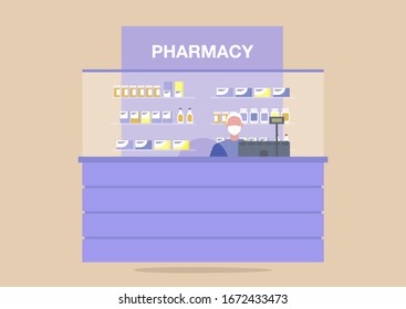 Pharmacy counter, young male pharmacist wearing a protective mask, coronavirus outbreak