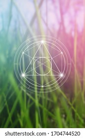 Philosopher stone sacred geometry spiritual new age futuristic illustration with transmutation interlocking circles, triangles and glowing particles in front of blurred natural background.