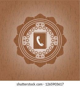 phonebook icon inside badge with wood background