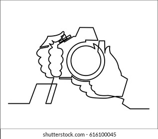 photo camera with hand holding it continuous line drawing in hand drawn sketch style