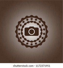 photo camera icon inside badge with wood background