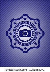 photo camera icon inside badge with denim texture