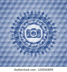 photo camera icon inside blue badge with geometric pattern.