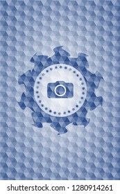 photo camera icon inside blue badge with geometric background.