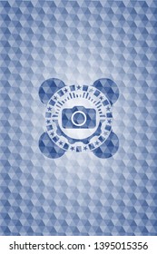 photo camera icon inside blue badge with geometric pattern.