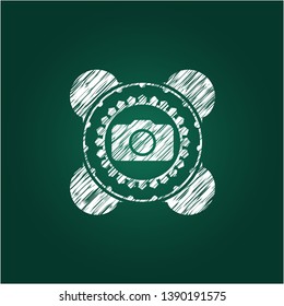 photo camera icon inside chalk emblem written on a blackboard