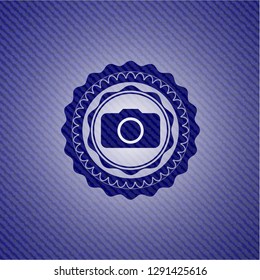 photo camera icon inside emblem with denim texture