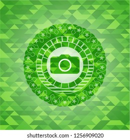 photo camera icon inside green emblem with triangle mosaic background