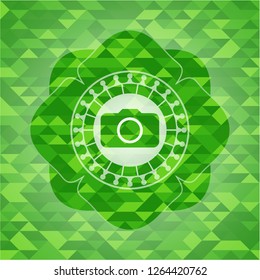 photo camera icon inside green emblem with triangle mosaic background