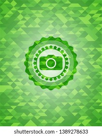 photo camera icon inside green emblem with mosaic background