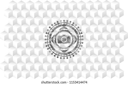 photo camera icon inside grey emblem with geometric cube white background
