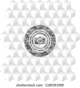 photo camera icon inside grey emblem with geometric cube white background