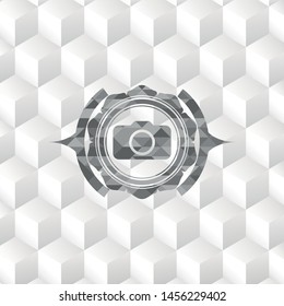 photo camera icon inside grey badge with geometric cube white background
